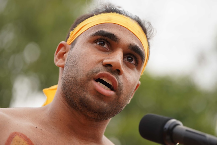 A tight shot of Michael looking serious as he speaks to the crowd.