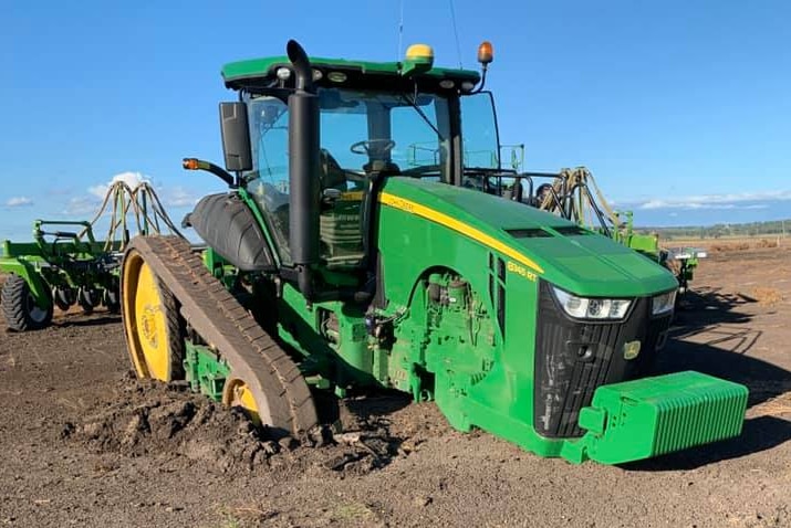 A piece of farm machinery stuck in mud.