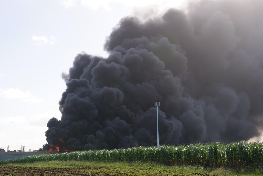 Large fire over a green field. 