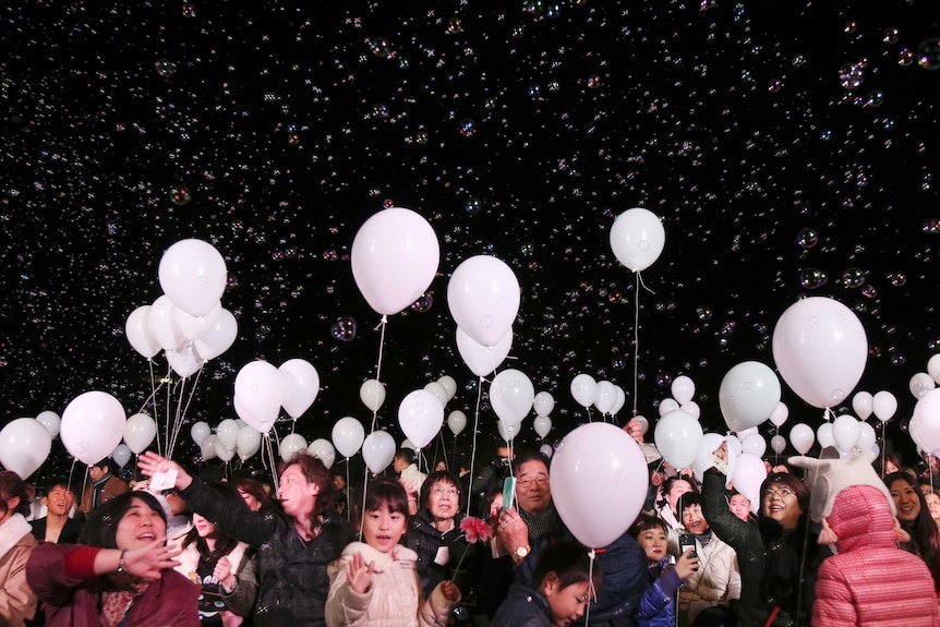 Bubbles float over visitors during a New Year's Eve celebration event a Tokyo Hotel, late Saturday, Dec. 31, 2016.