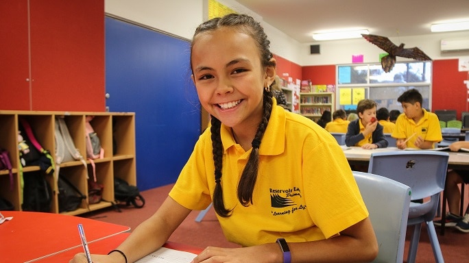 Bridget Green a grade three student from Reservoir East Primary School smiles while doing her finance homework.