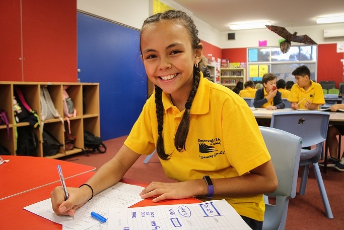 Bridget Green a grade three student from Reservoir East Primary School smiles while doing her finance homework.