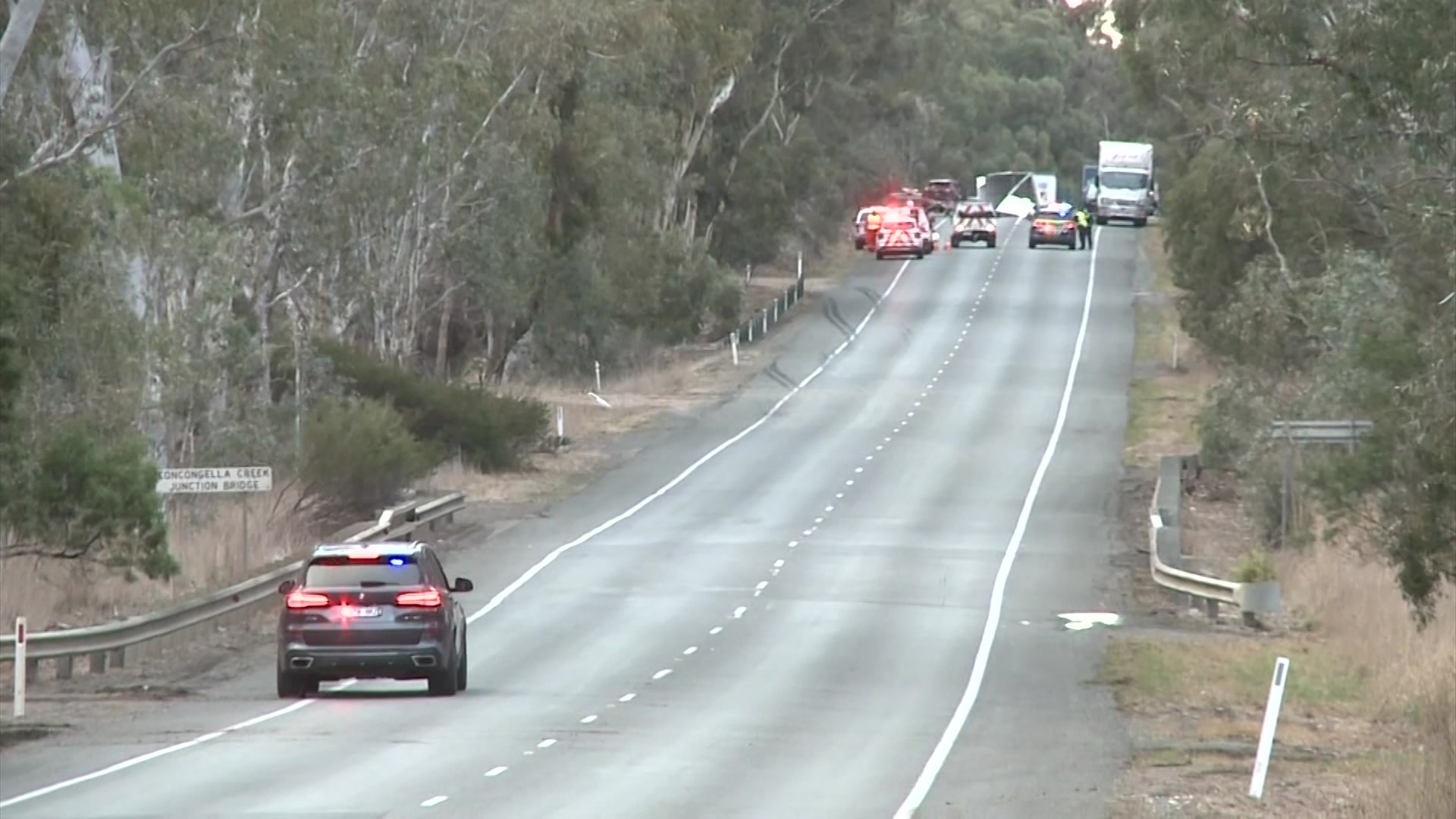 A highway with an accident scene in the background