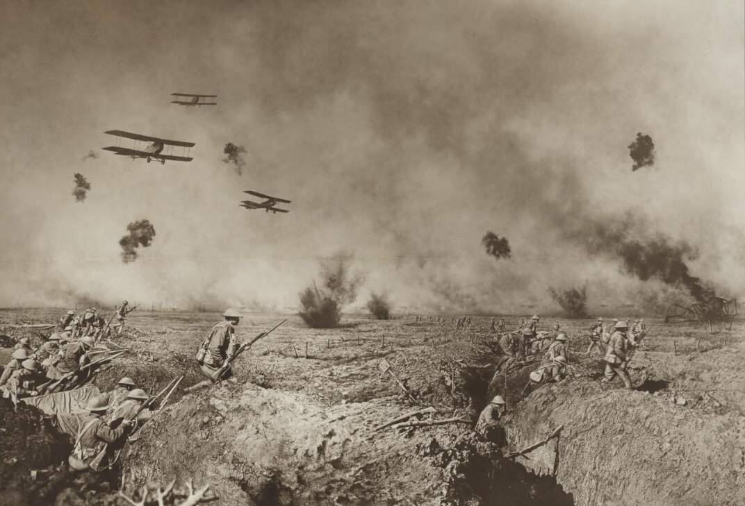 An old sepia photograph of soldiers on a battlefield with shells exploding in the background