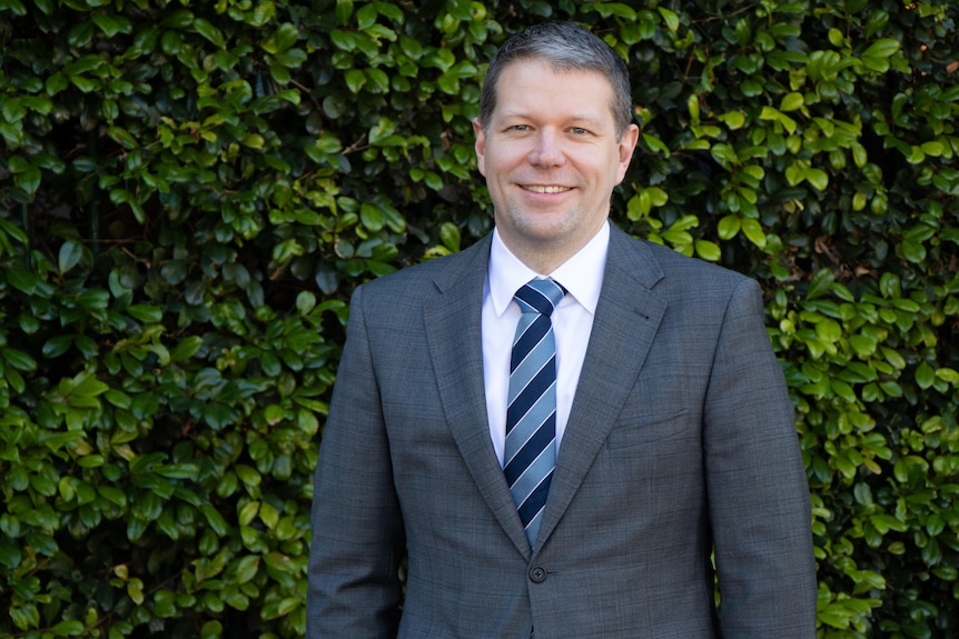 Chris Mountford dressed in a grey suit.