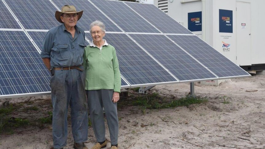 Cape Le Grande farmers John and Val Locke stand in front of large solar panels on their property.