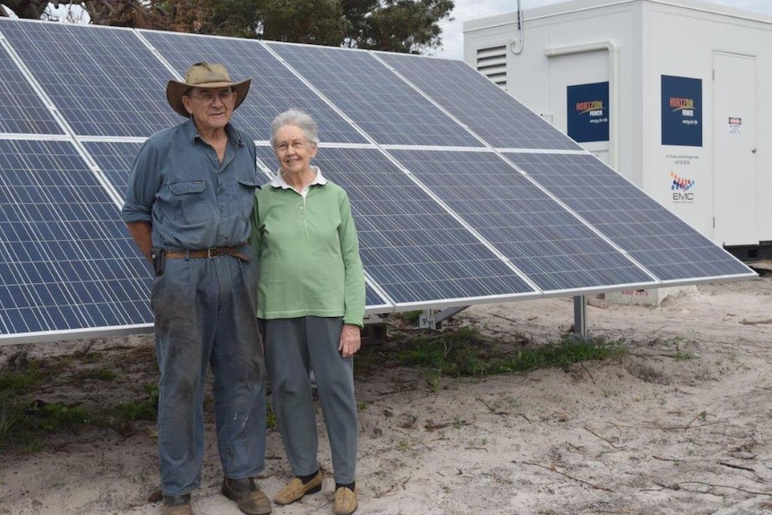 Cape Le Grande farmers John and Val Locke stand in front of large solar panels on their property.