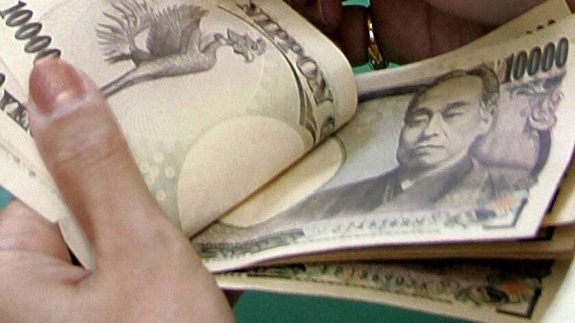 Hands flick through Japanese yen banknotes