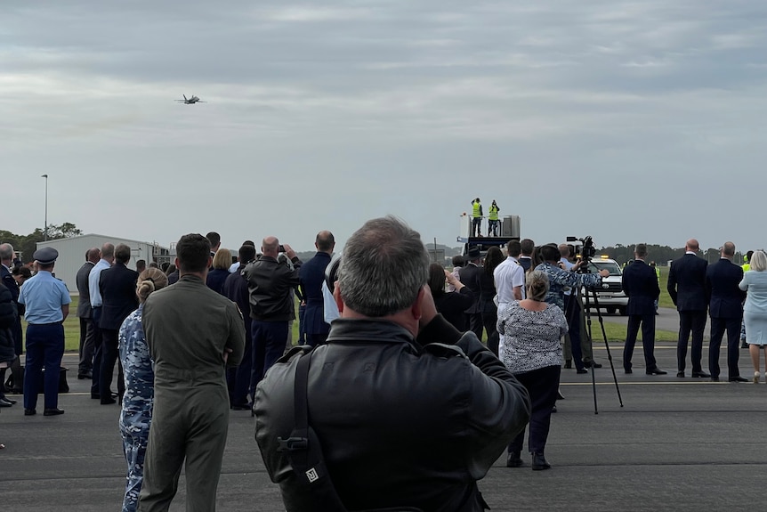 Wide shot of a crowd watching an aircraft display