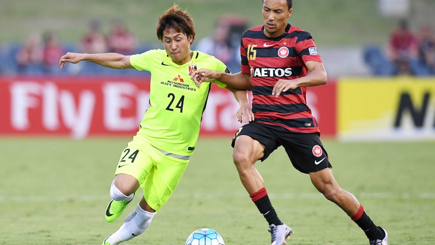 Kearyn Baccus (R) of the Wanderers competes for the ball with the Red Diamonds' Takahiro Sekine