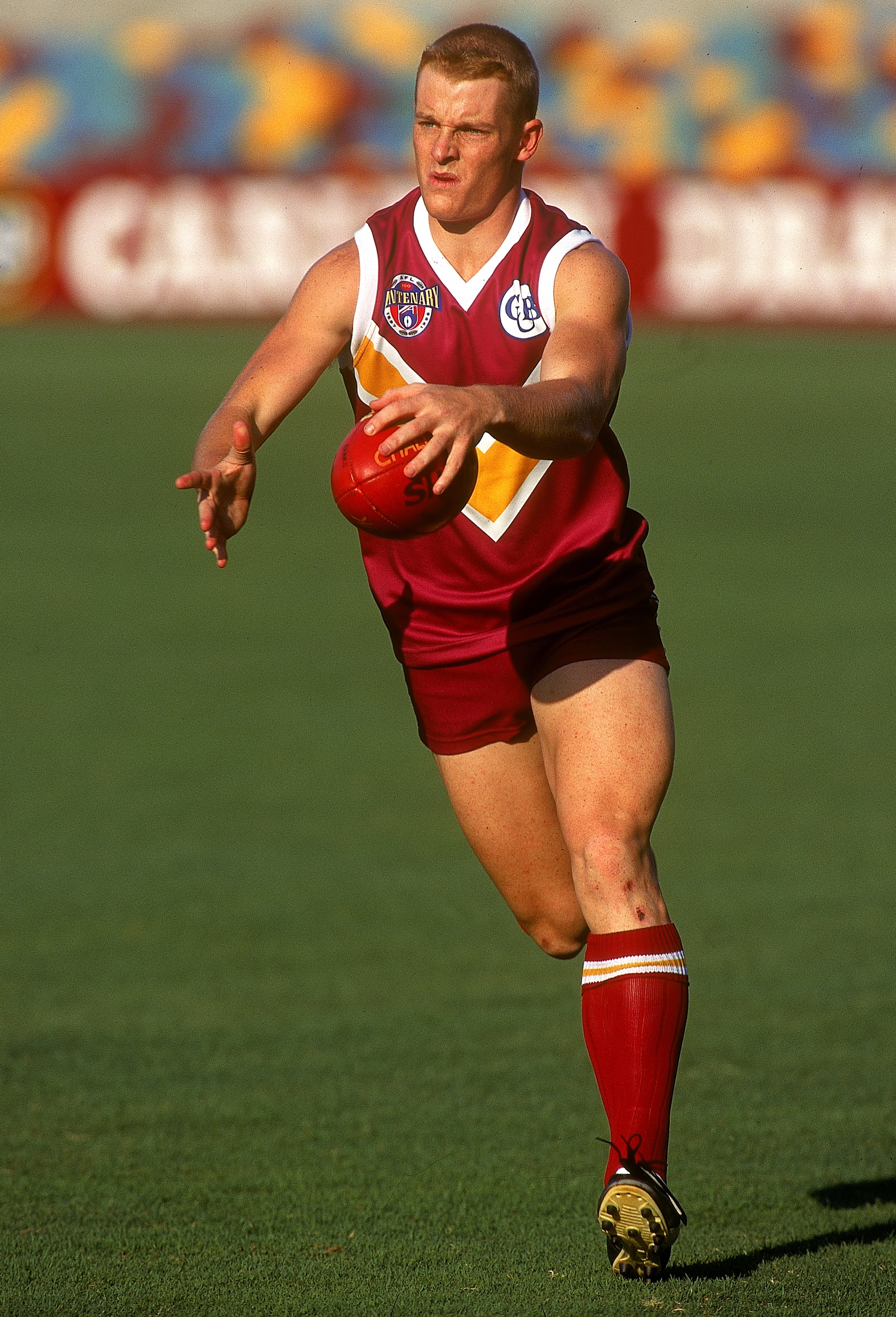 Michael Voss prepares to kick a football with ball in hand
