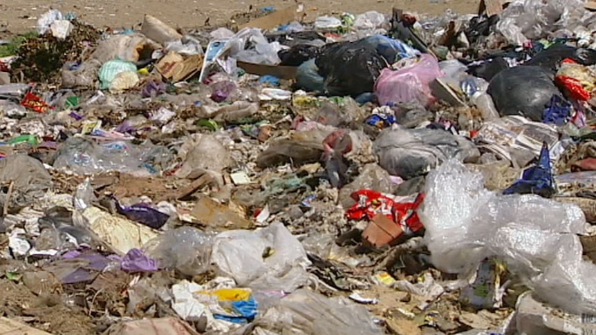 Pieces of rubbish on the ground at a landfill site.