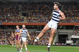 Geelong's Tom Hawkins watches his kick in the preliminary final against the Brisbane Lions.