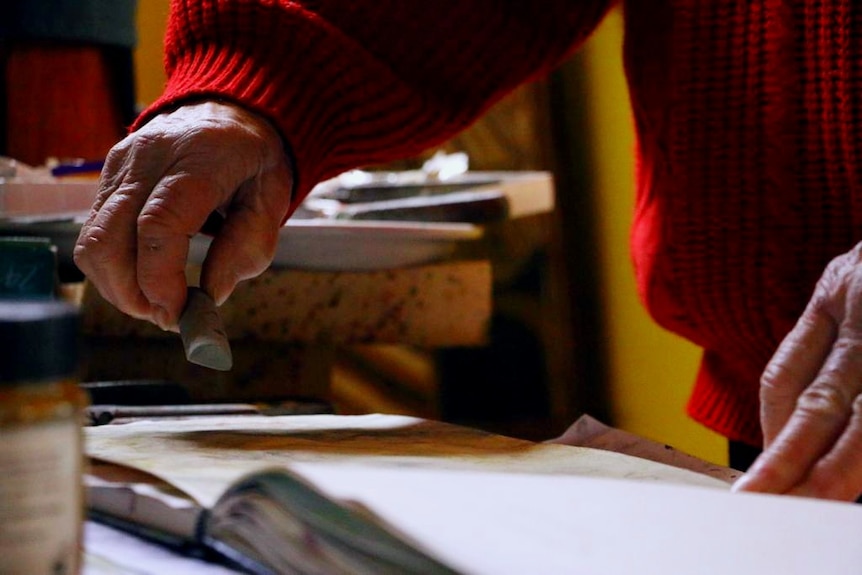 Barbara McKay's hands as she prepares to draw on paper. 