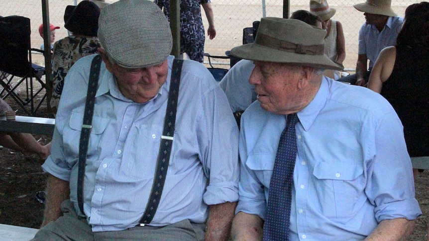 Jim Clifton and Peter Weston, sitting in the shade of the bush grandstand at Come by Chance race course.