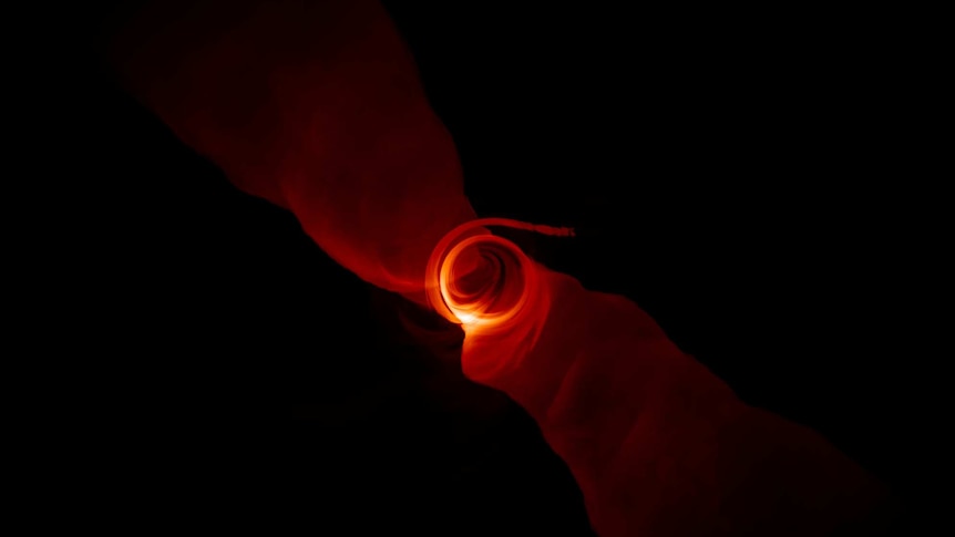 A swirl of red light against a black background.