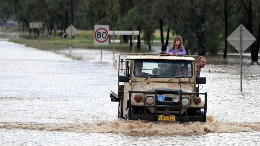 A 4WD makes its way through floodwaters in Wee Waa.