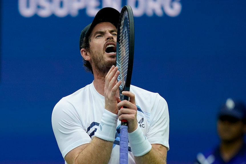 Andy Murray holds his racket and screams.