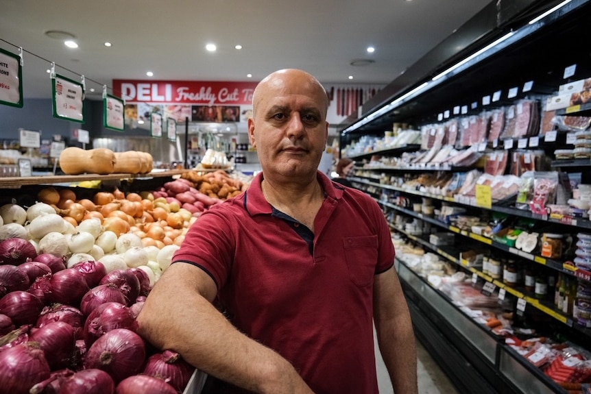 a man in front of fruit and vegetables looking