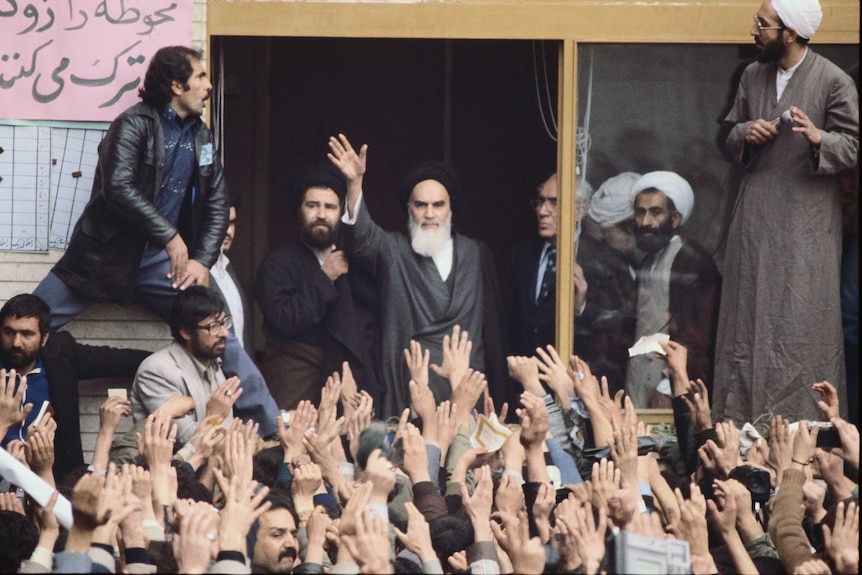 Ayatollah Khomeini waves to a crowd of enthusiastic supporters on his return to Tehran.