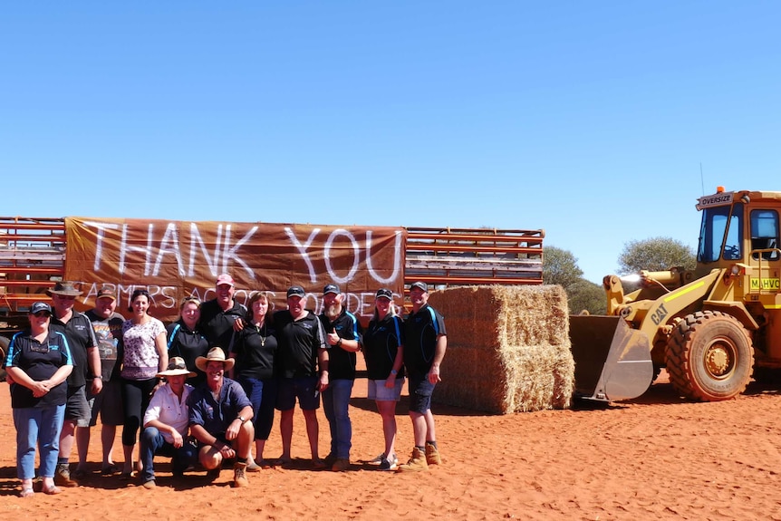 A group of people stand with a thank you sign