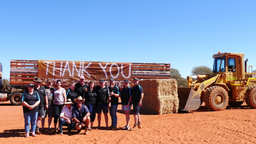 A group of people stand with a thank you sign