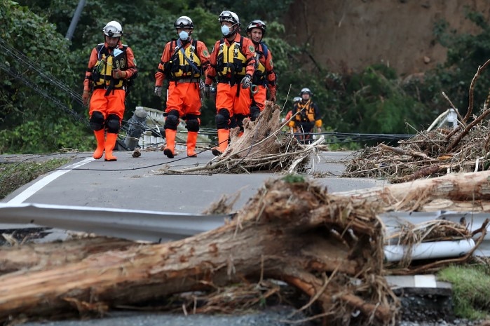 Rescuers walk through wreckage caused by Typhoon Hagibis.