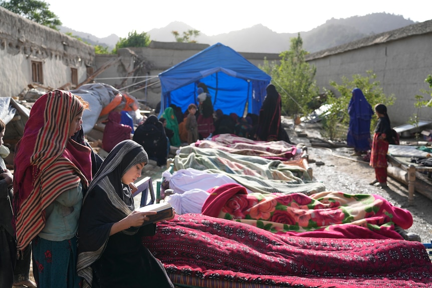 Niños rezan junto a los cuerpos de las víctimas del terremoto en Afganistán 