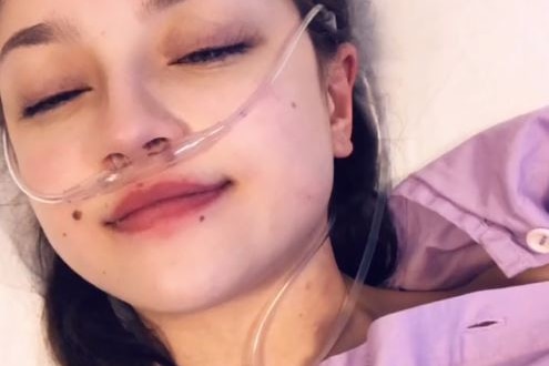 Ksenia Borodin takes a selfie while in hospital with oxygen tube.