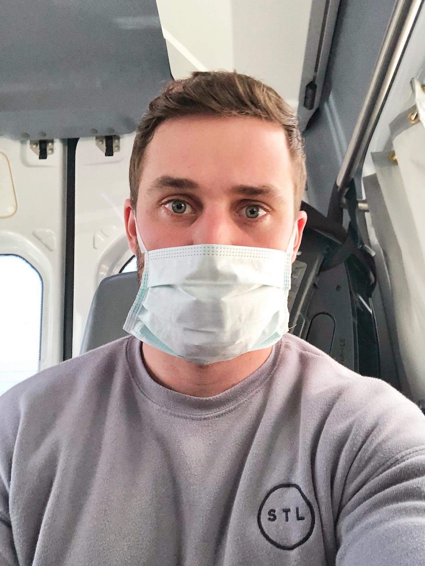 A man wears a face mask in an ambulance.