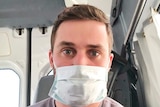 A man wears a face mask in an ambulance.