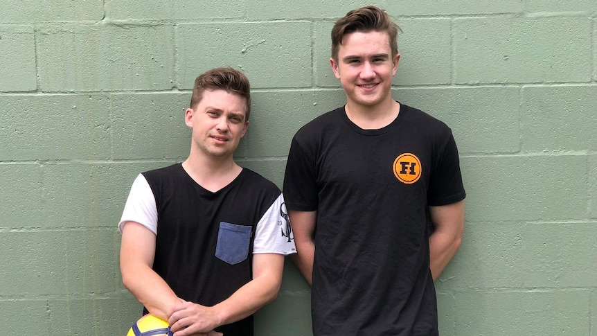 Ben Crew and his brother James standing in front of a wall.
