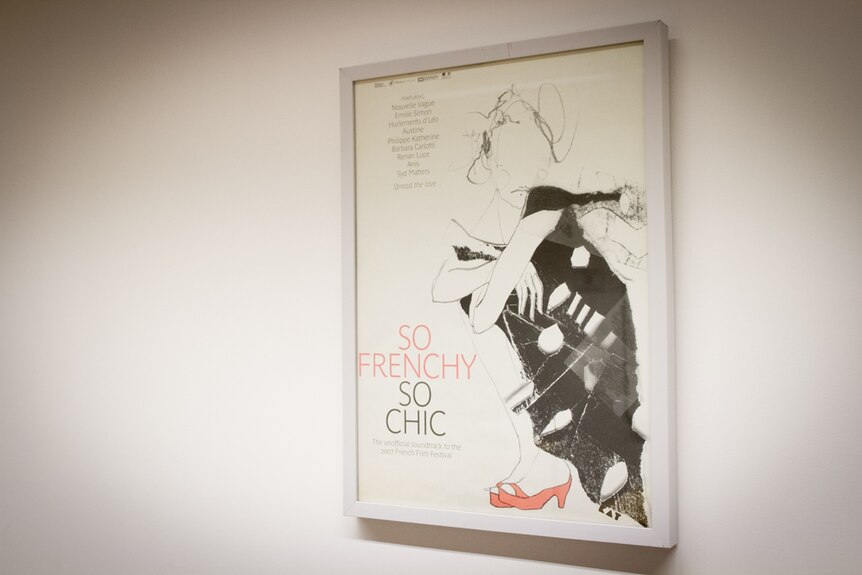 A French poster hanging on a wall.