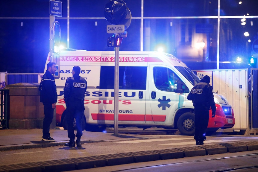 An emergency vehicle and police on a street.