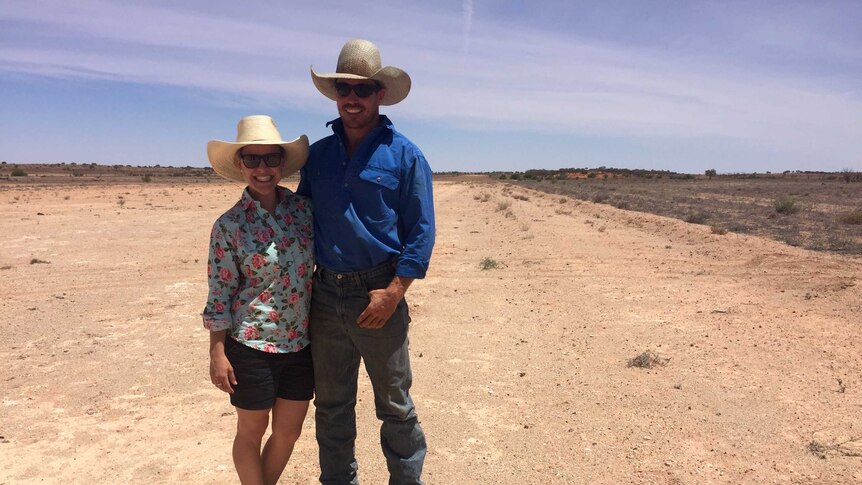 Emma and Fred Osman stand on the airstrip at a remote Queensland station near the NSW border.
