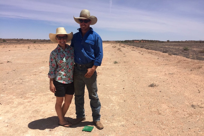 Emma and Fred Osman stand on the airstrip at a remote Queensland station near the NSW border.