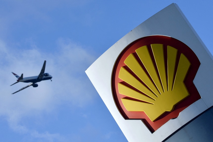 Left a passing airplane and on the right side the Shell logo.