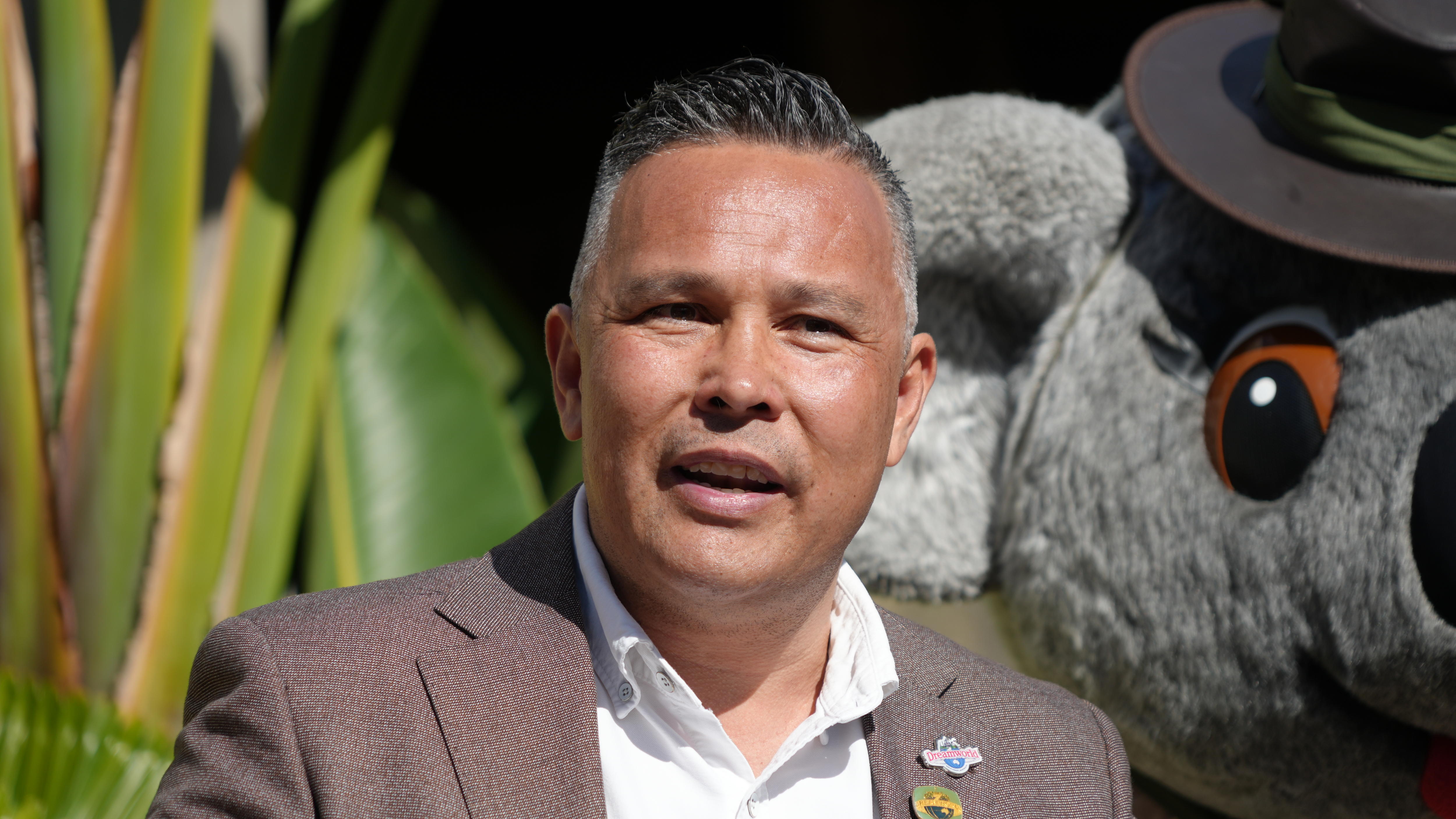 A man in front of a big koala costume.
