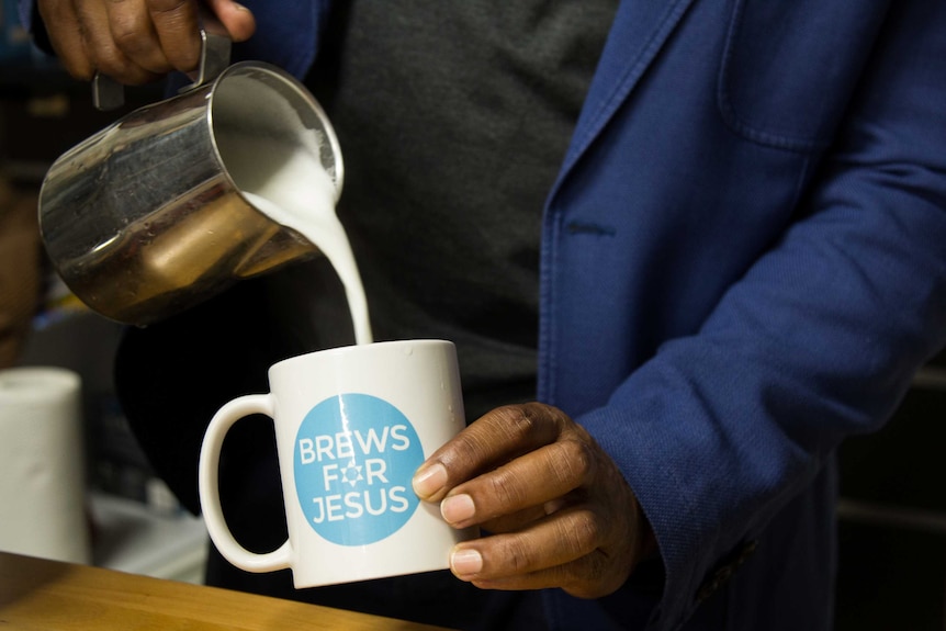 Milk being poured into a 'Brews for Jesus' coffee mug.