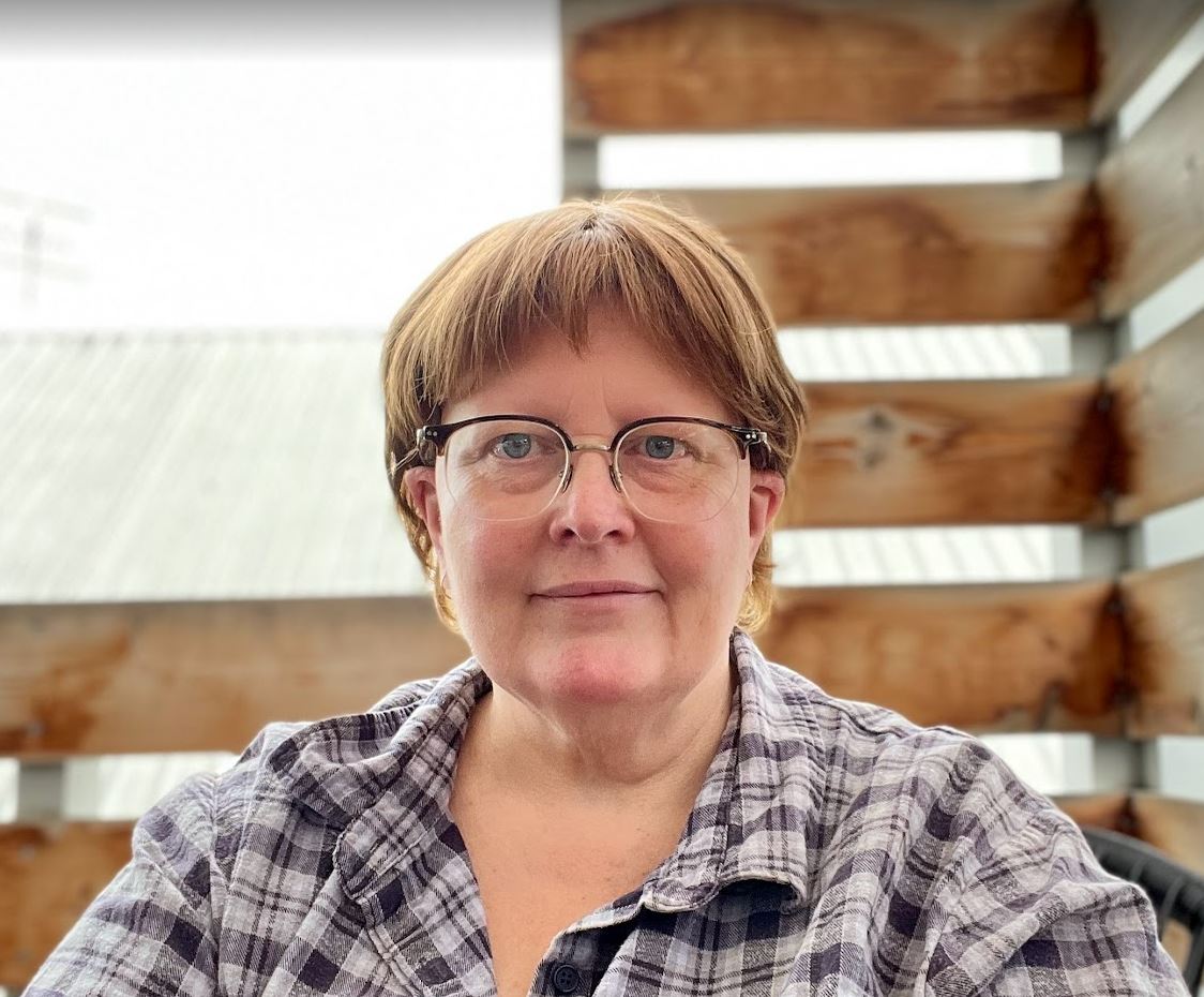 A headshot of a woman wearing glasses.