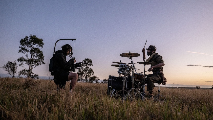 Polaris drummer in a field with camera man