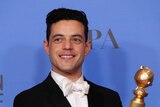Rami Malek smiles as he holds his Golden Globe award for best actor in a motion picture - drama