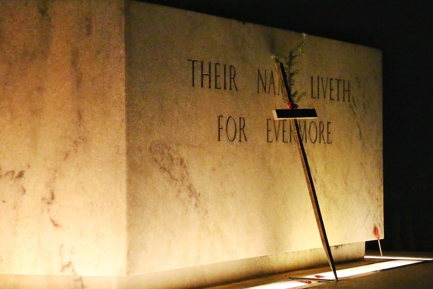 A cross sits in front of a memorial at the Australian War Memorial in Canberra.