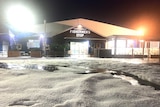 Hail on the ground after a storm leaves a car park looking like it's been snowing