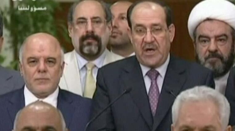 Nouri al-Maliki (centre) announces he will step aside