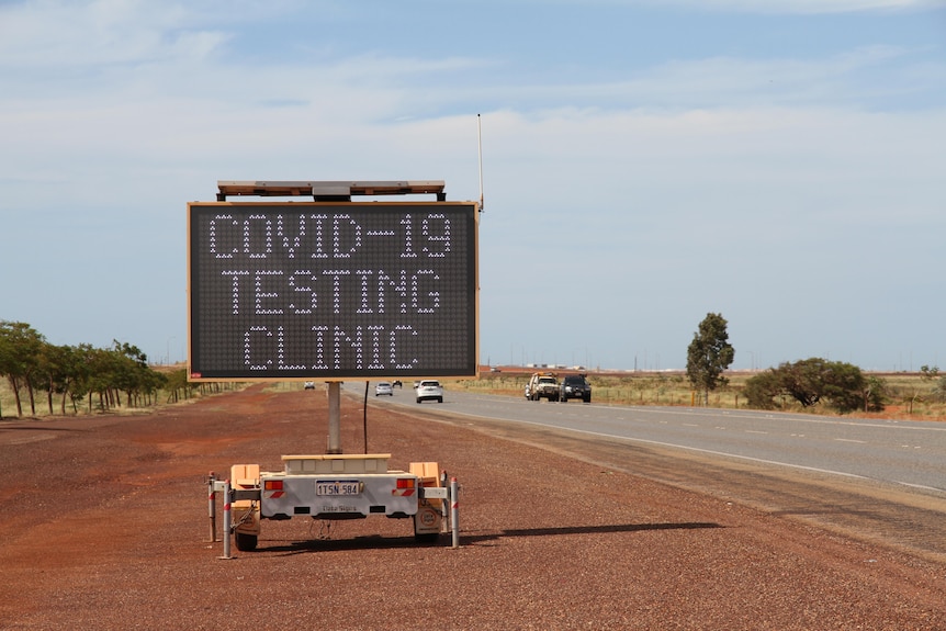 A large sign on a highway says "COVID-19 testing clinic".