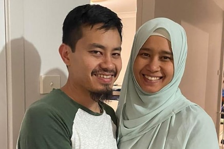 A young man and his sister are pictured hugging.