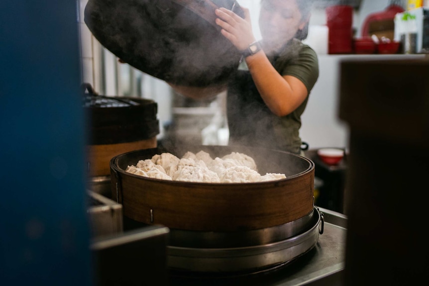 Steamed pork buns being cooked a steamer