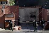 Afghan security forces guard a guesthouse after an attack in Kabul