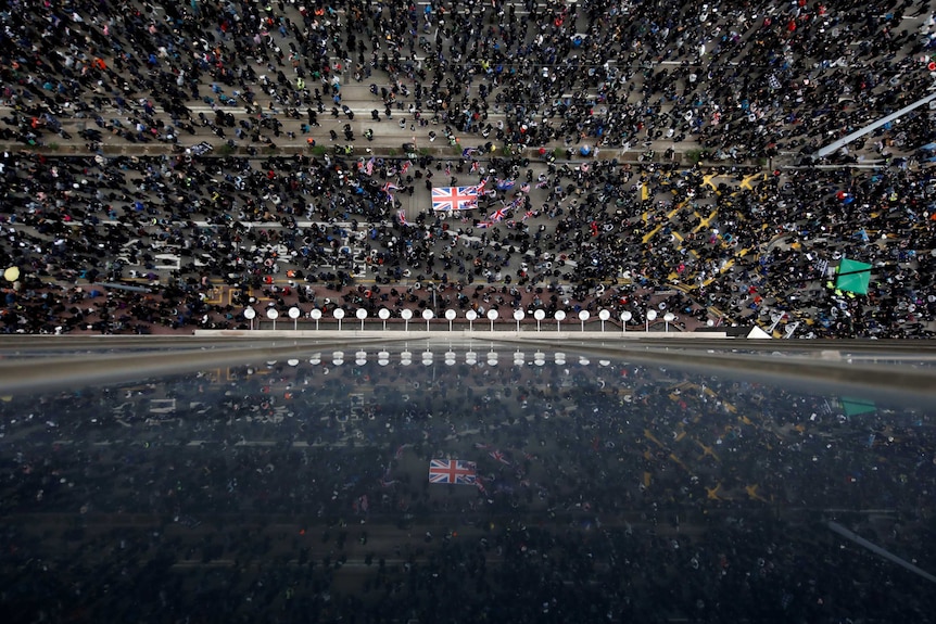 Aerial shot of protesters marching on street.